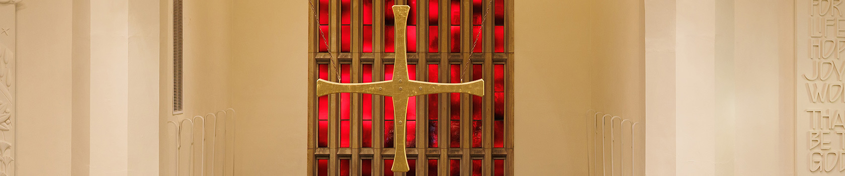 Gold Cross Against Stained Glass